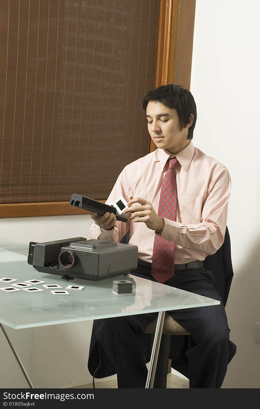 Man puts slides in a slide show projector. Vertically framed photo. Man puts slides in a slide show projector. Vertically framed photo.