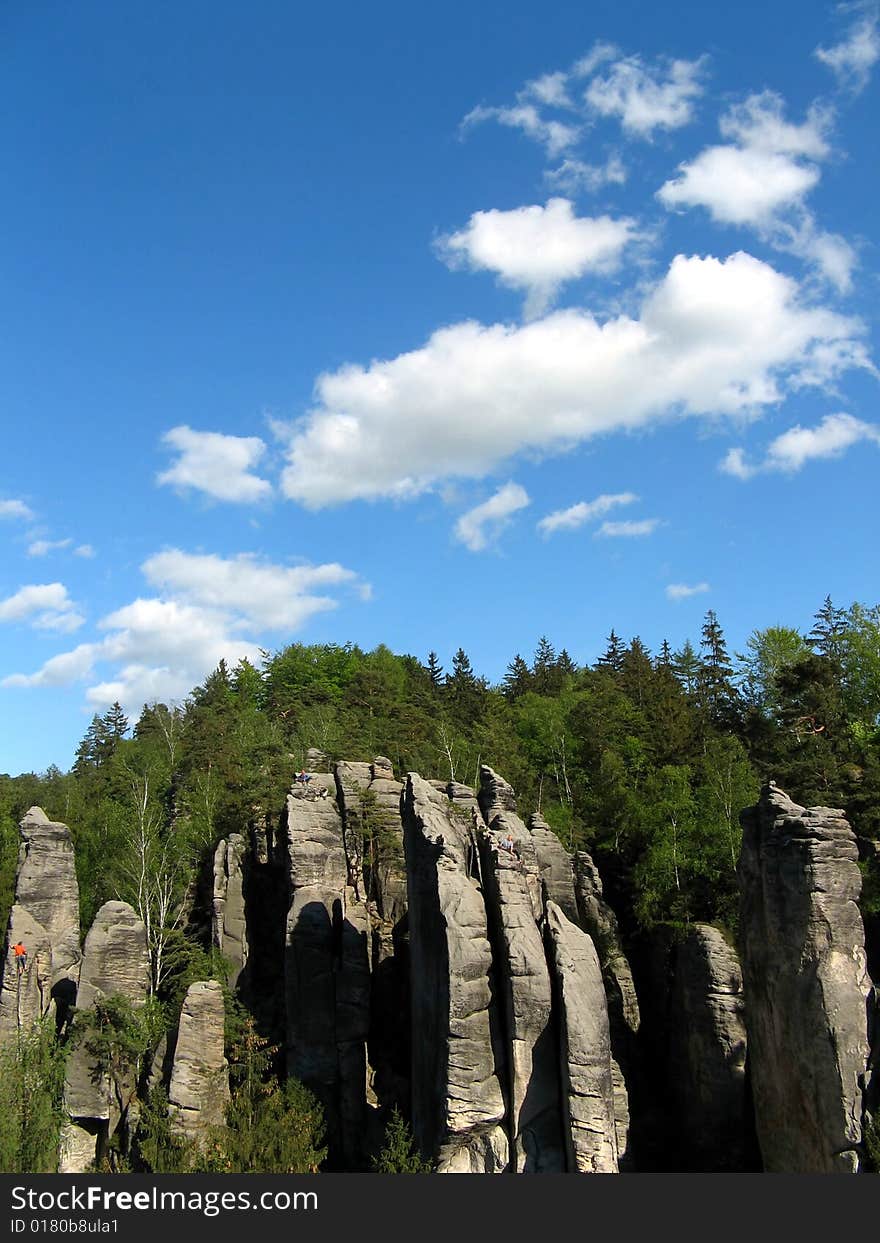 Blue sky and white clouds over forest and rock towers. Blue sky and white clouds over forest and rock towers
