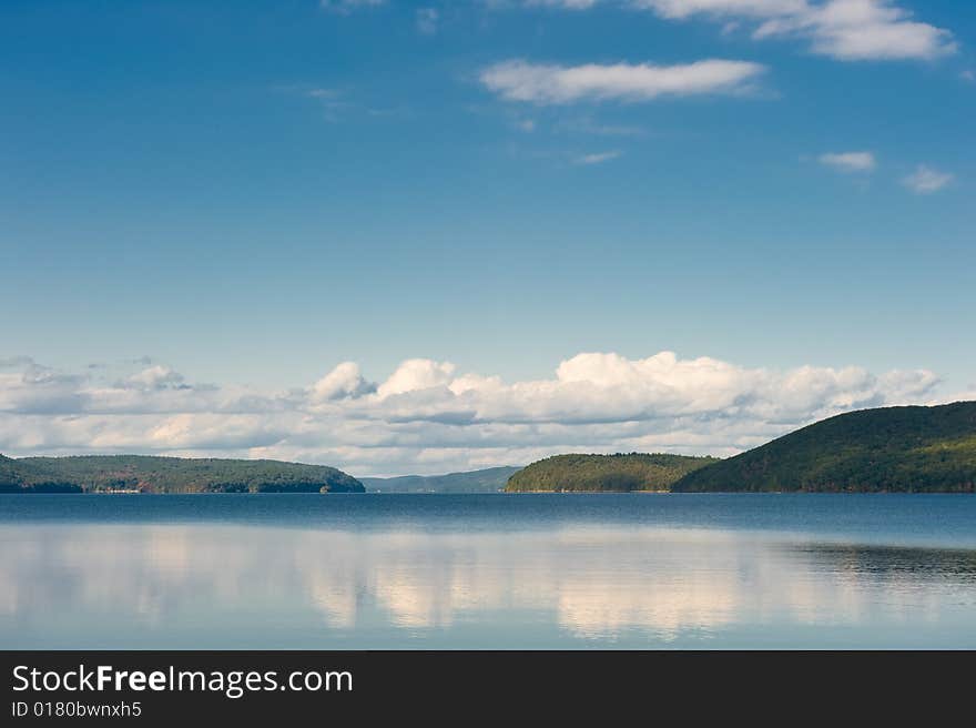 Clouds and the sky are reflected in lake water. Clouds and the sky are reflected in lake water