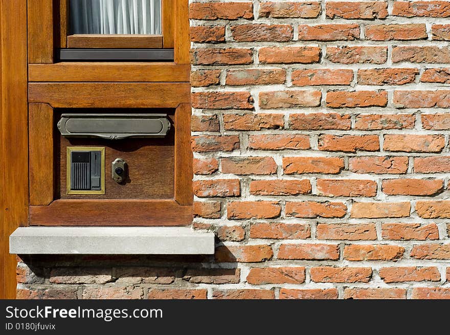 Wall with wooden section, door bel, postal slot, window