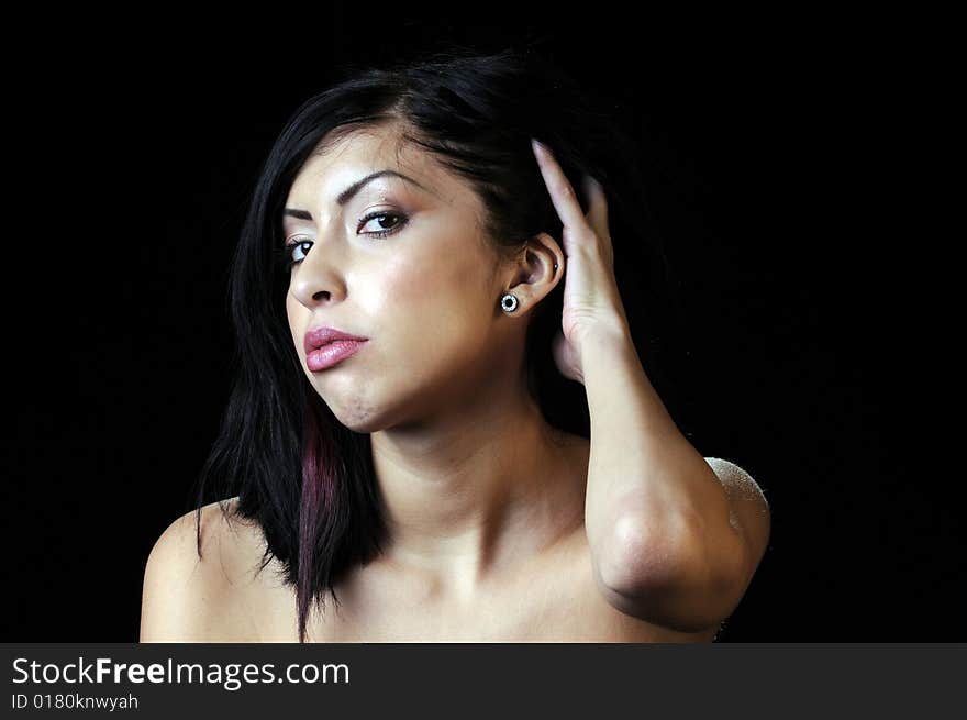 Beautiful young brunette Hispanic woman pulling hair back. Beautiful young brunette Hispanic woman pulling hair back