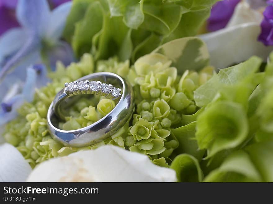 Closeup of wedding rings on bouquet DOF focus on diamonds