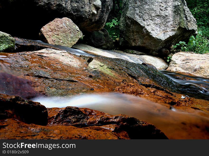 This picture was taken in remote mountains in China's Guangdong Province, where many streams and rocks, clear spring water bottom, and the formation of a number of small waterfalls