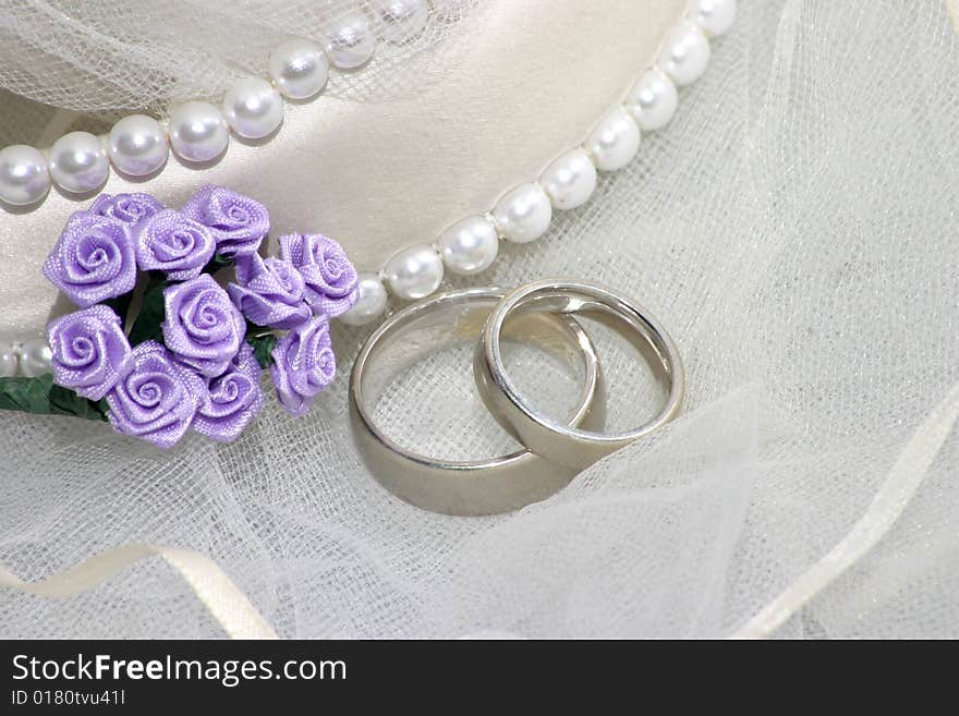 Wedding bands on veil with purple flowers. Wedding bands on veil with purple flowers