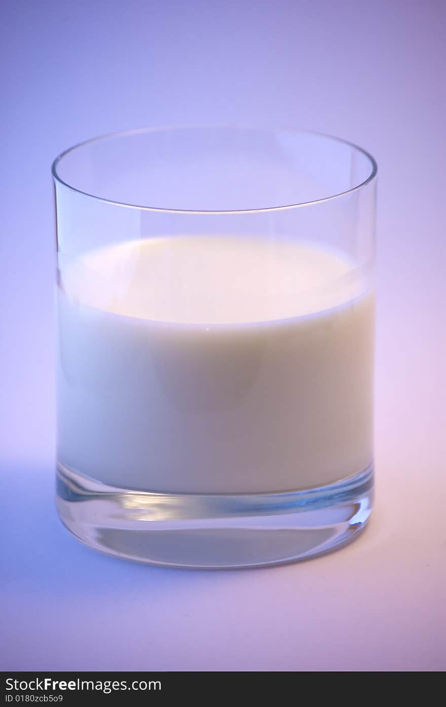 A glass of milk on a simple background.