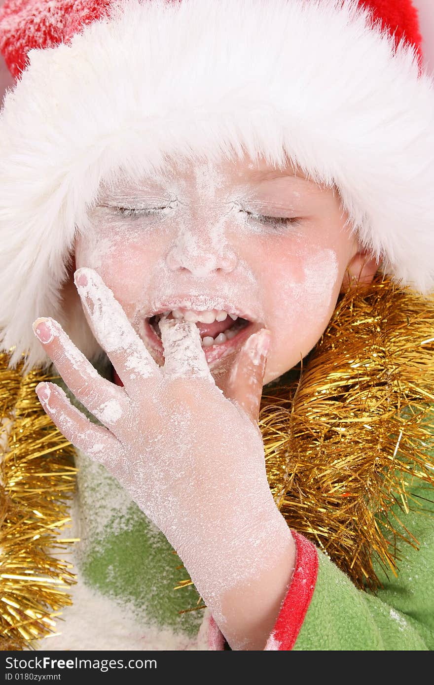 Toddler wearing a christmas hat, baking christmas cookies