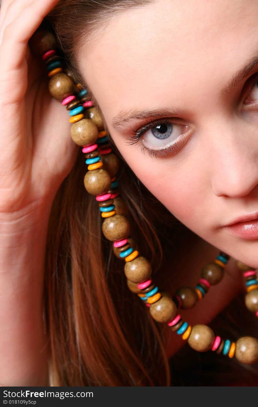 Beautiful female model with blue eyes and a string beads