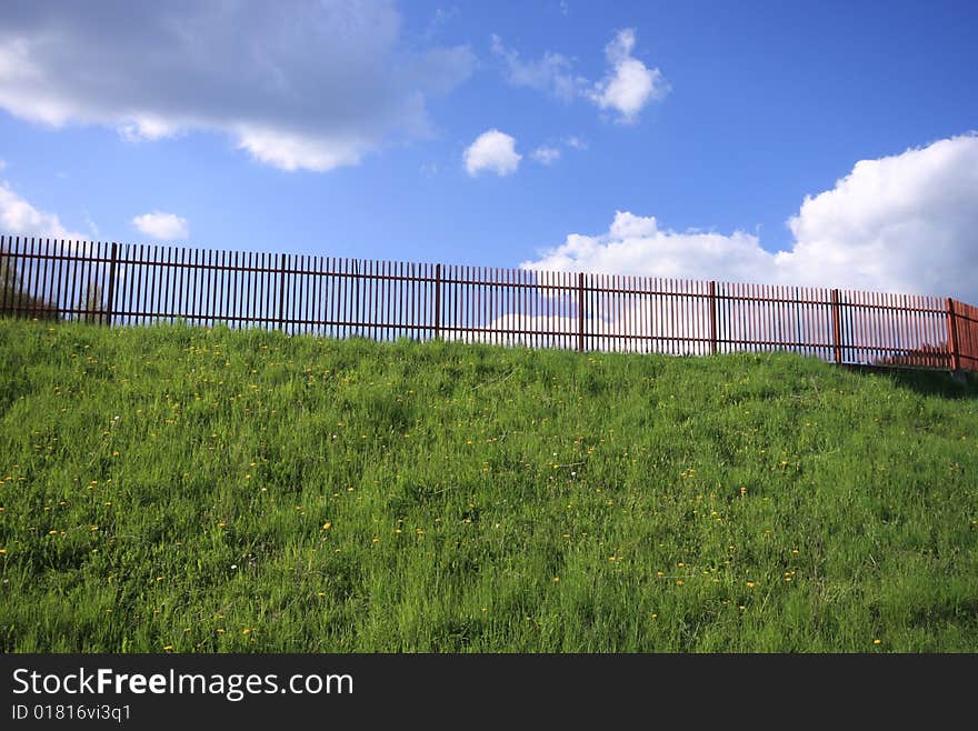 Fence on the grassy hill.