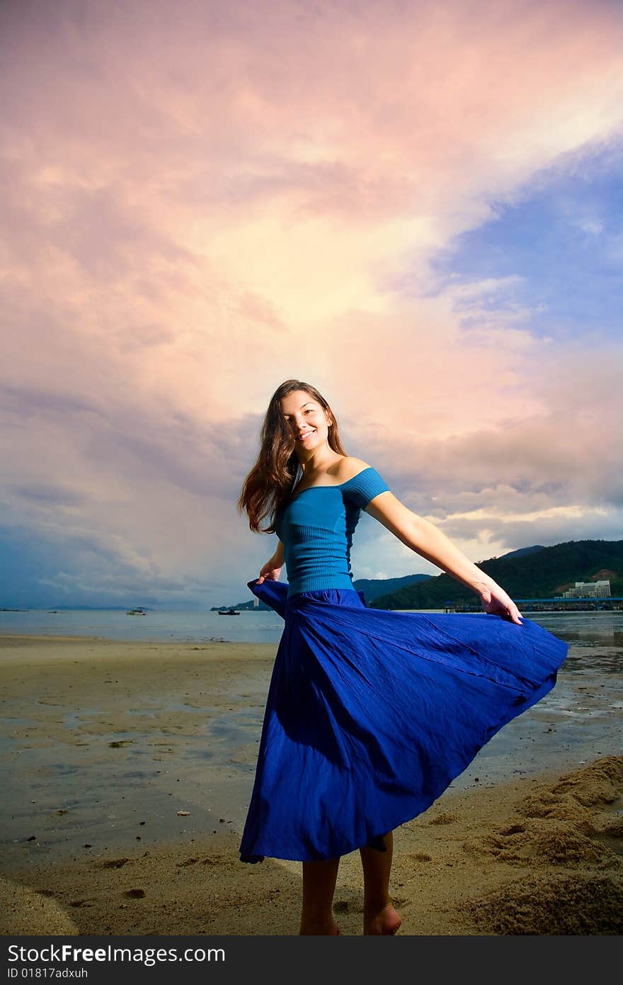 Young eurasian woman at the sunset beach