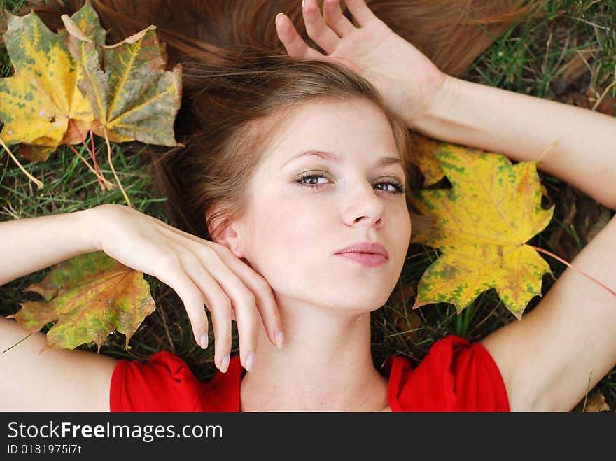 Young beautiful woman with maple leaf around her face