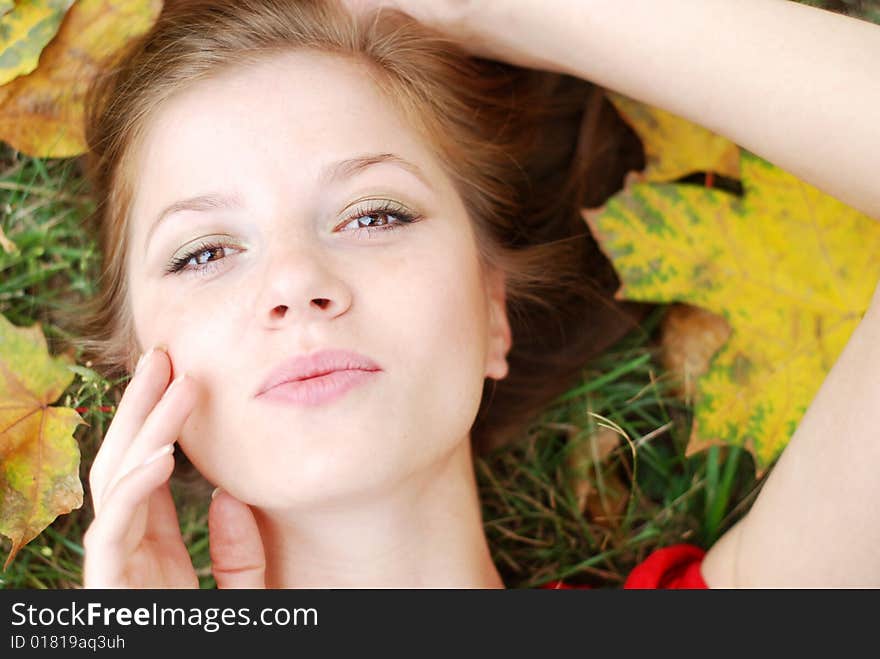 Young beautiful woman with maple leaf around her face