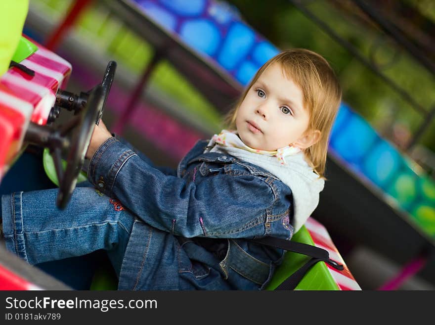 Small beauty girl at park amusement - on small toy machine, drive