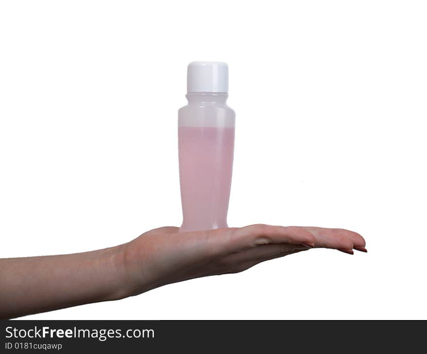 The female hand holds on an open palm a small bottle with perfumery on a white background. The female hand holds on an open palm a small bottle with perfumery on a white background