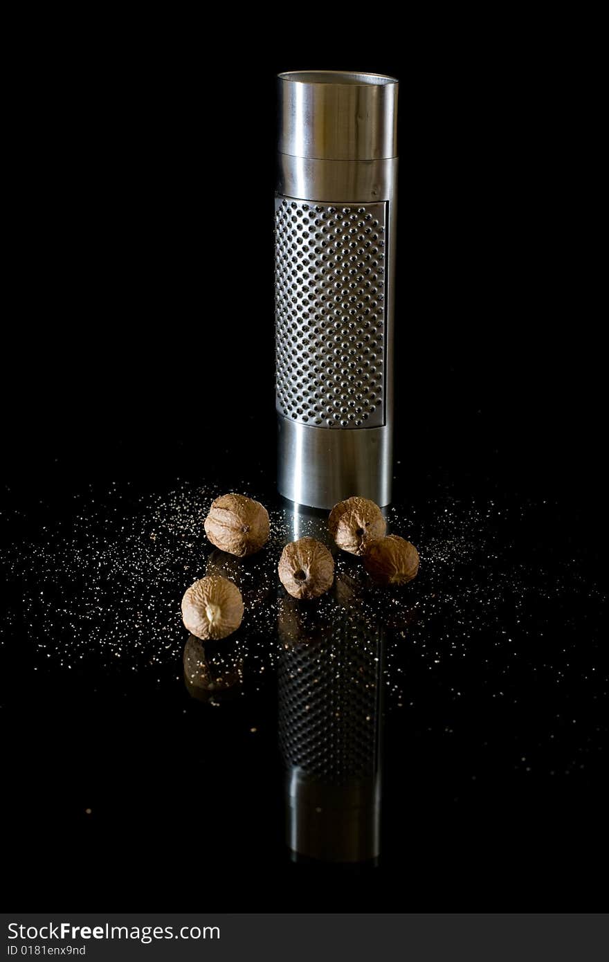 Nutmeg and silver grater on black background