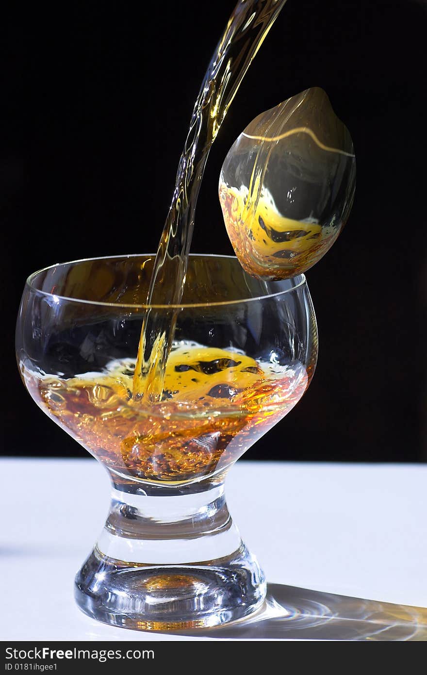 Glass with the poured liquid and an abstract lemon. Glass with the poured liquid and an abstract lemon