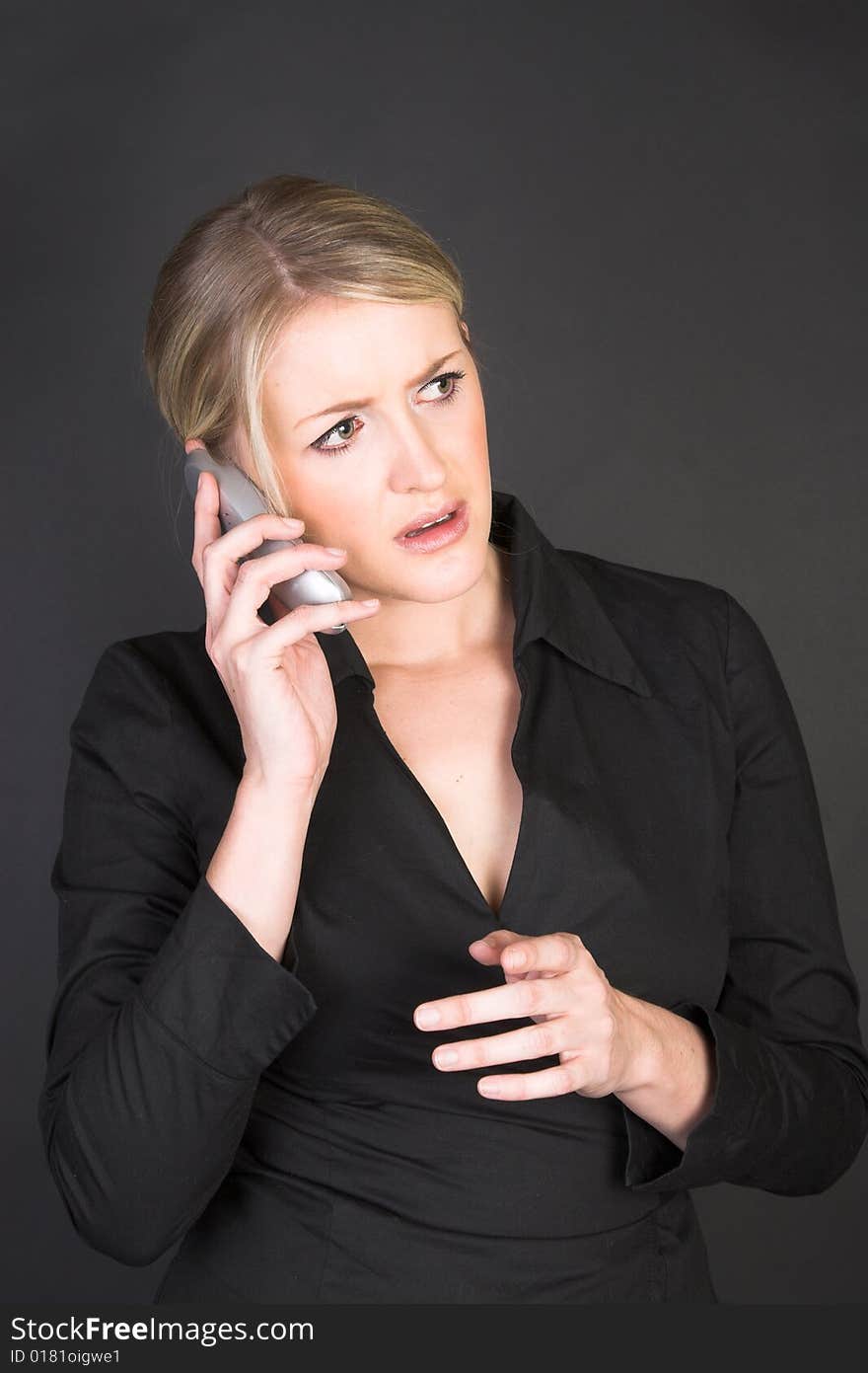 Worried looking blond businesswoman in conversation on the phone. Worried looking blond businesswoman in conversation on the phone