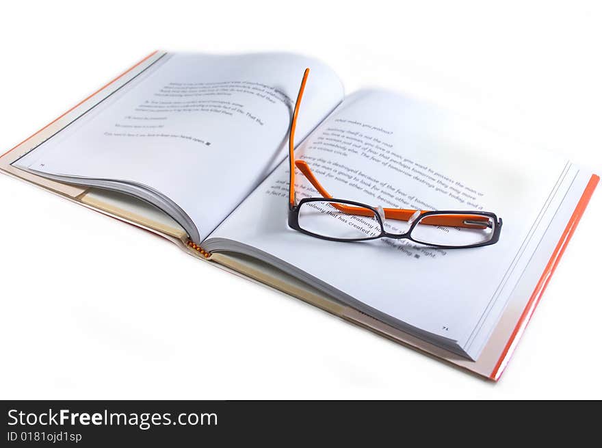 Orange and black spectacles on an open book. Orange and black spectacles on an open book.