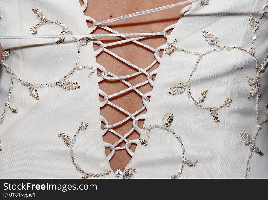 Close up of wedding gown bodice being laced up