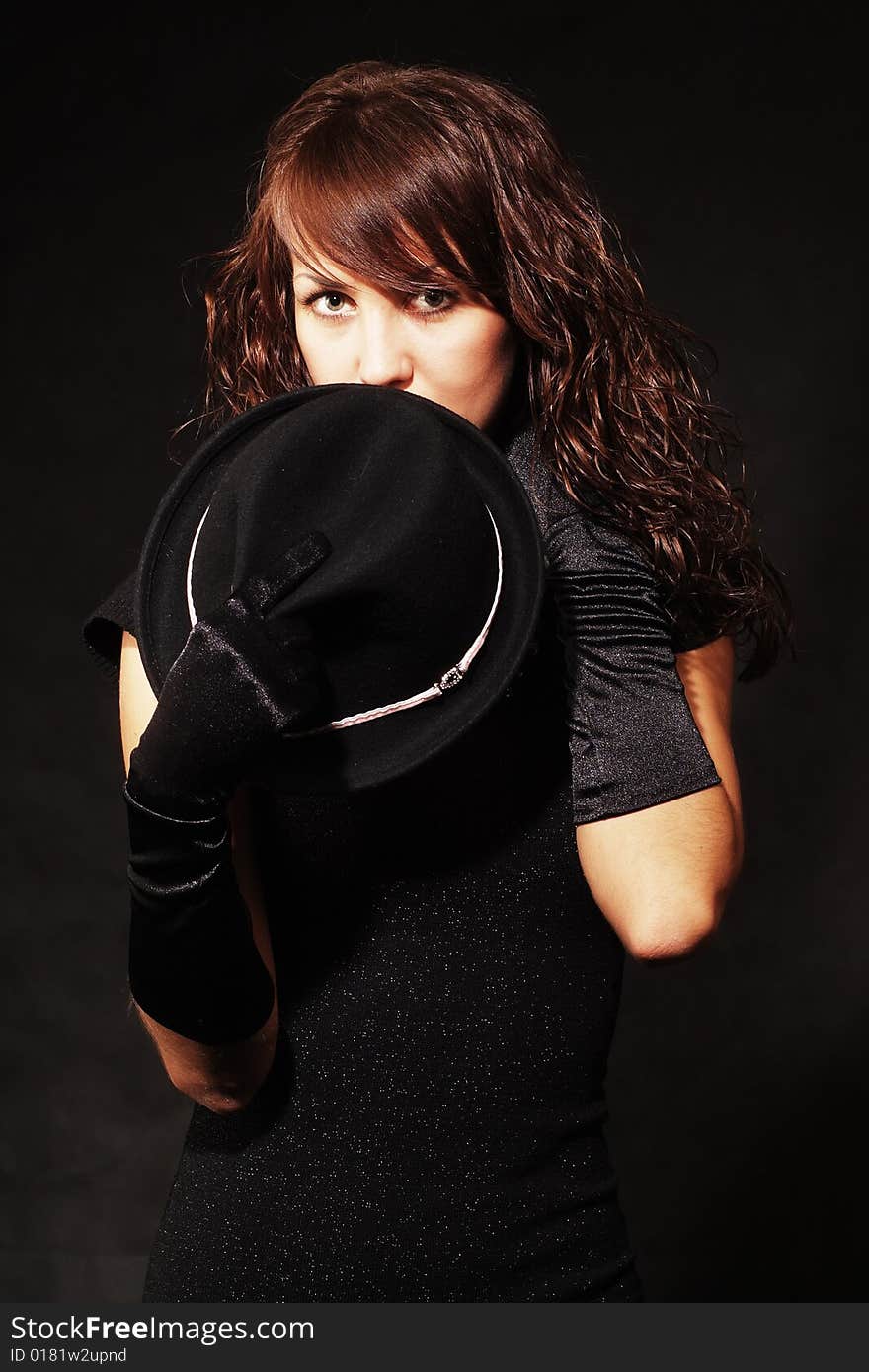 The girl in black clothes on a white background with a hat hat