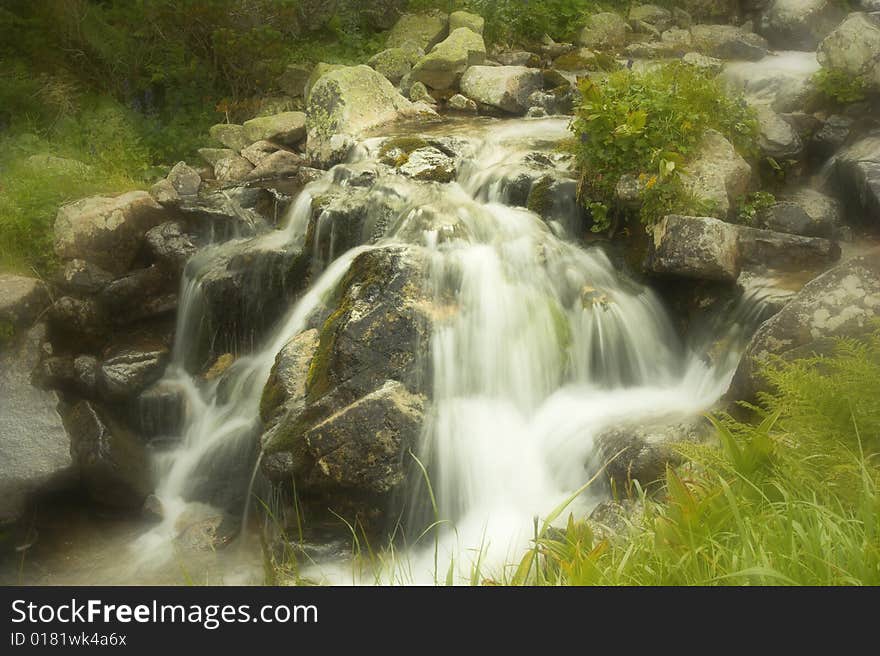 The mountany stream with a small waterfall. The mountany stream with a small waterfall