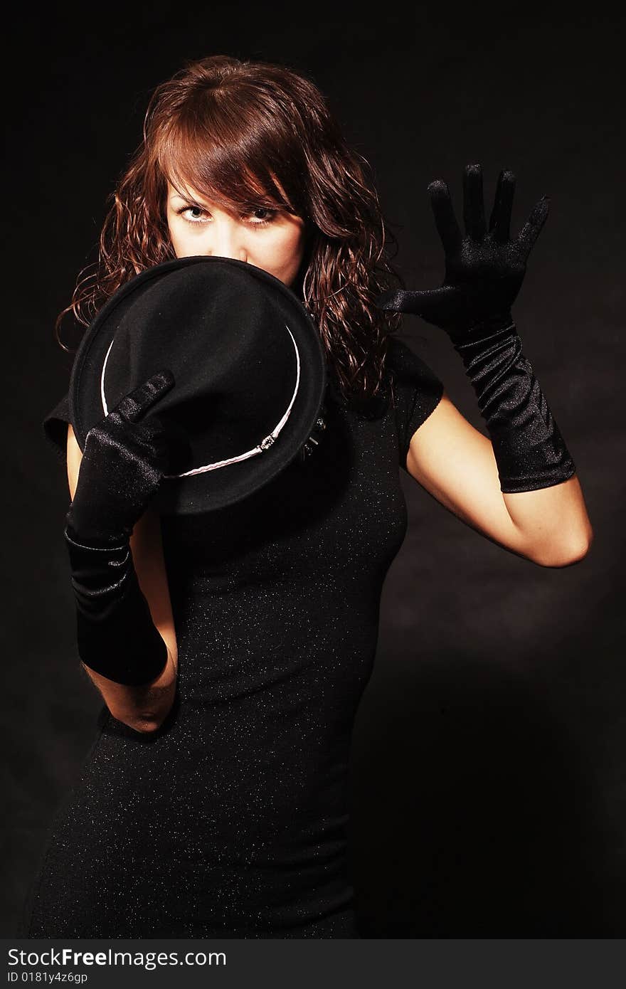 The girl in black clothes on a white background with a hat hat