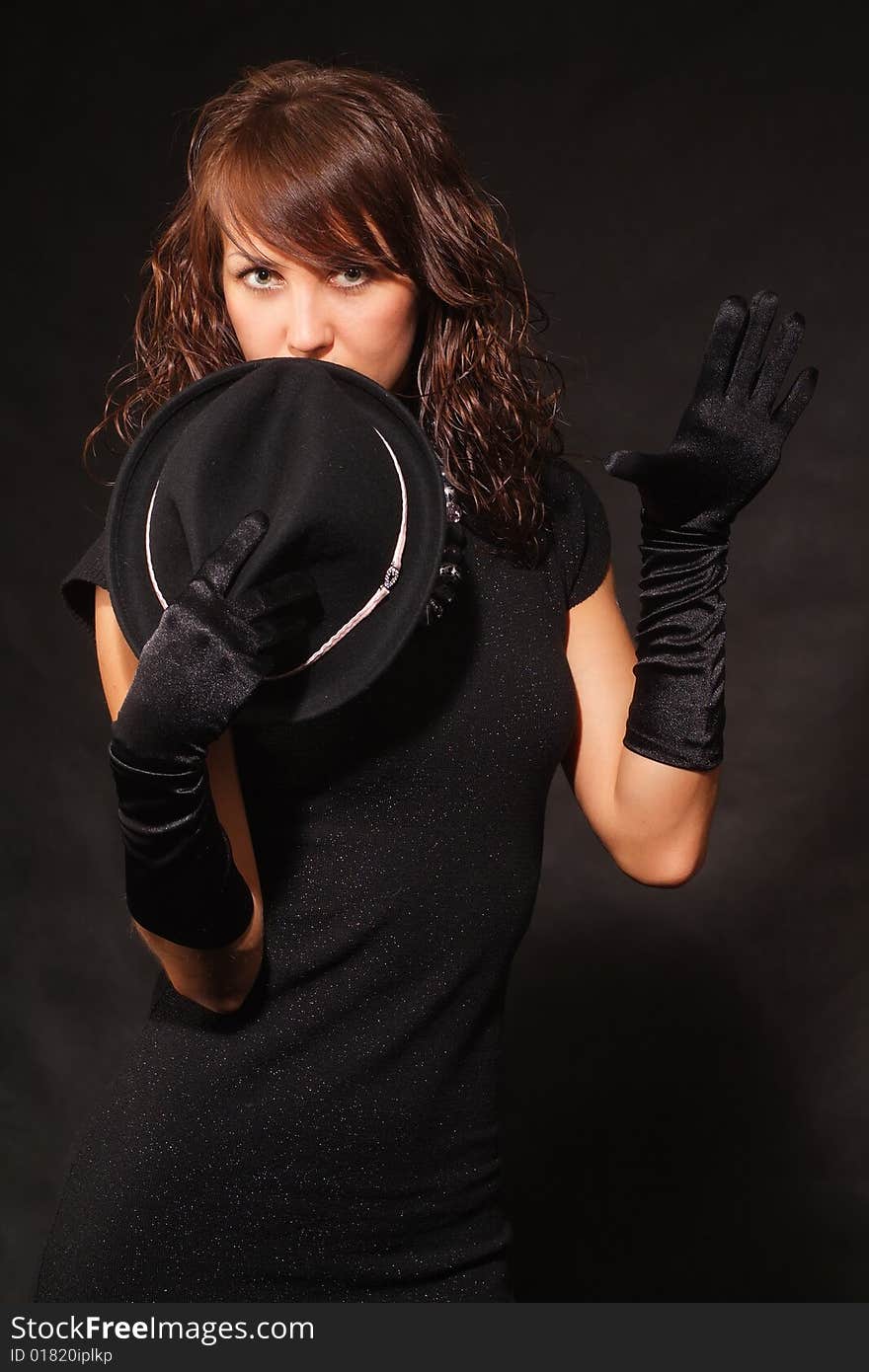 The girl in black clothes on a white background with a hat hat