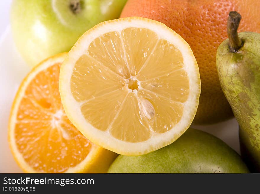 Fruit salad with lemon on the top. Contains many different citrus fruits