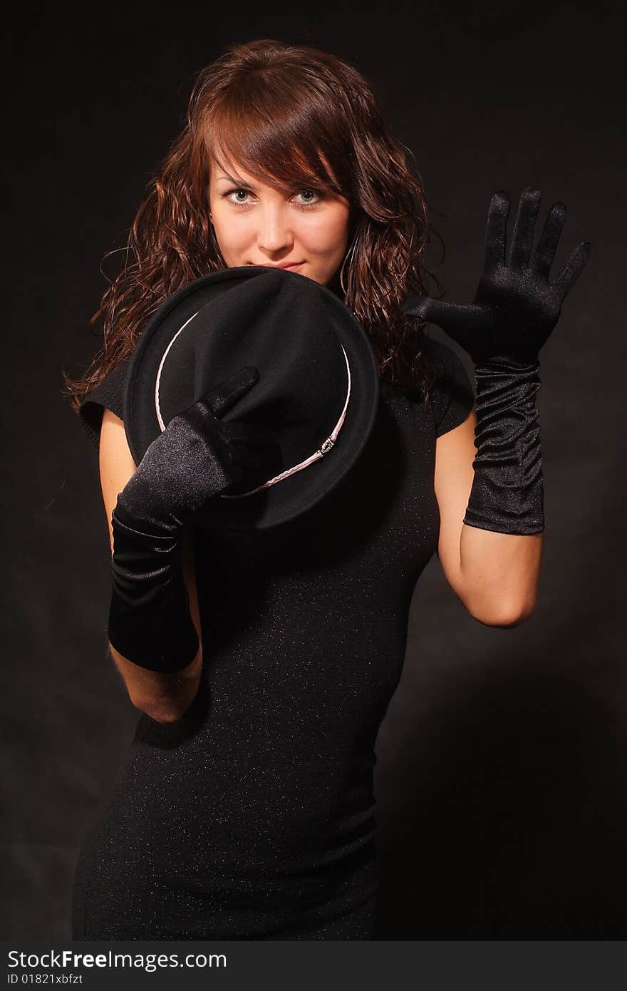 The girl in black clothes on a white background with a hat hat