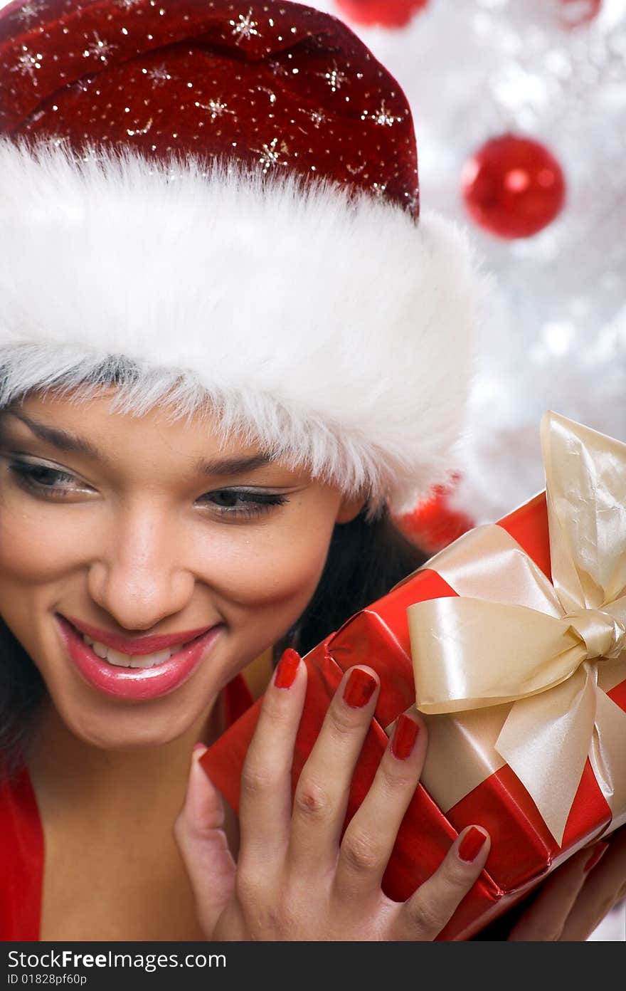 Smiling christmas woman isolated on white background with a gift and a tree