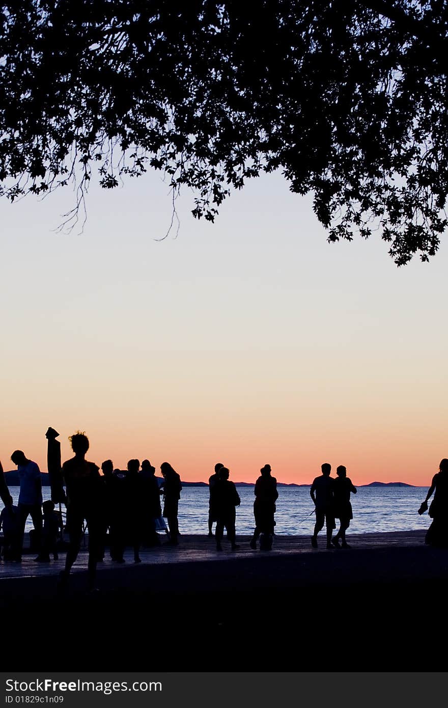 People by the sea at sunset in Zadar, croatia