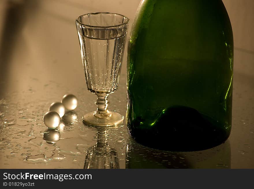 Glass with champagne and green bottle. Glass with champagne and green bottle