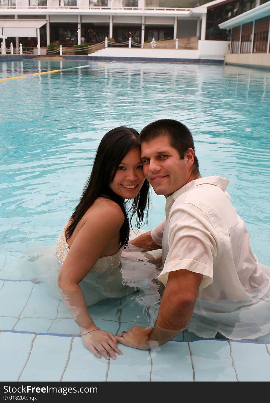 Bride and groom in the swimming pool - trash the dress trend. Bride and groom in the swimming pool - trash the dress trend.