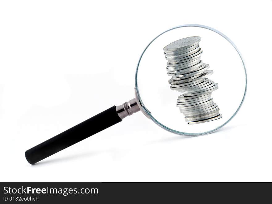 Magnifying glass with a small column of coins behind it. Magnifying glass with a small column of coins behind it.