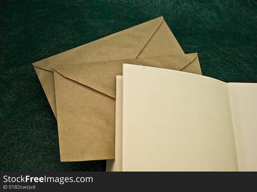 Open book and envelopes on a green background