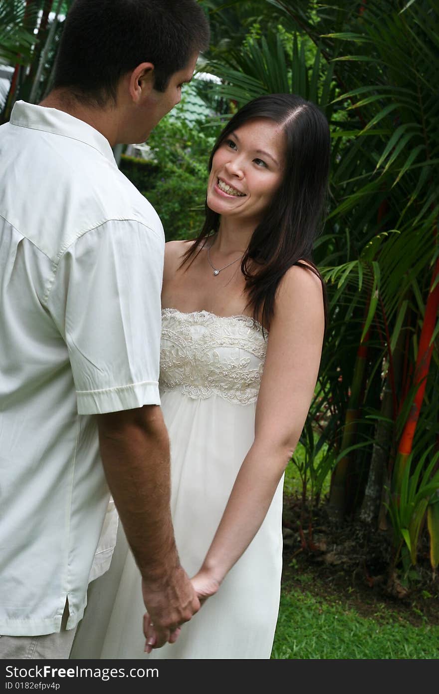 Happy bride and groom in a garden. Happy bride and groom in a garden.