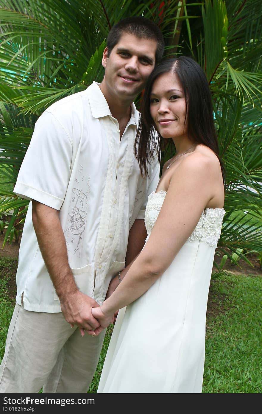 Happy bride and groom in a garden. Happy bride and groom in a garden.