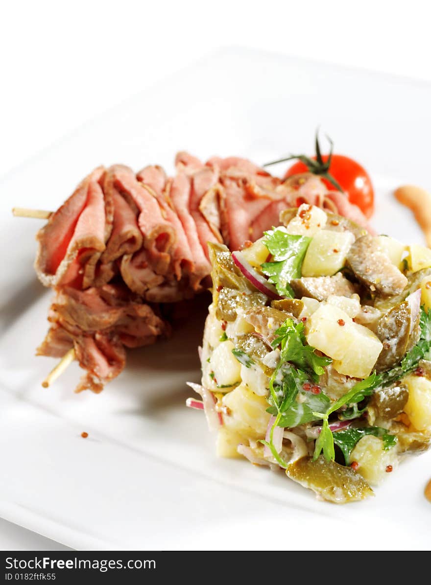 Roast Beef Served with Salad (Potatoes and Vegetables) and Cherry Tomato. Isolated on White Background