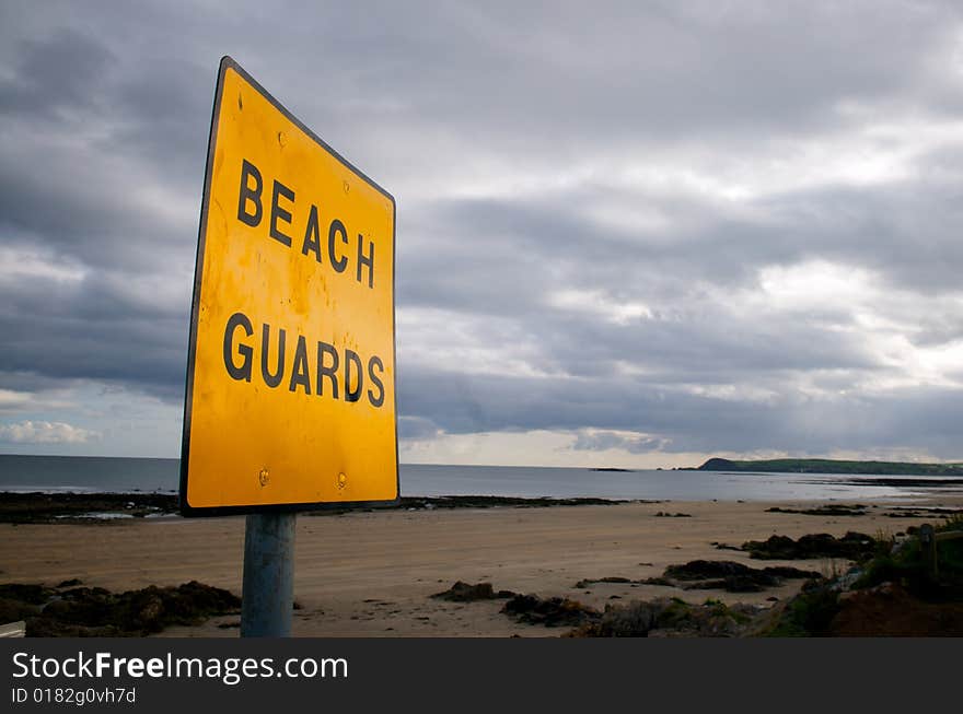 A deserted beach showing a Beach Guard Sign. A deserted beach showing a Beach Guard Sign