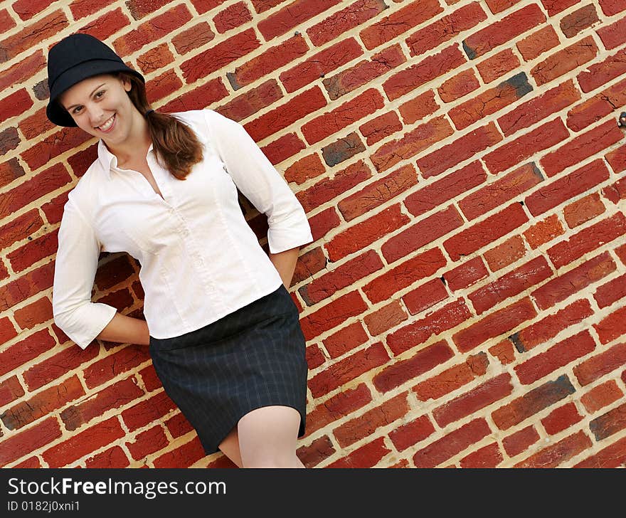 Fashionable young woman posing in front of a brick wall. Fashionable young woman posing in front of a brick wall.