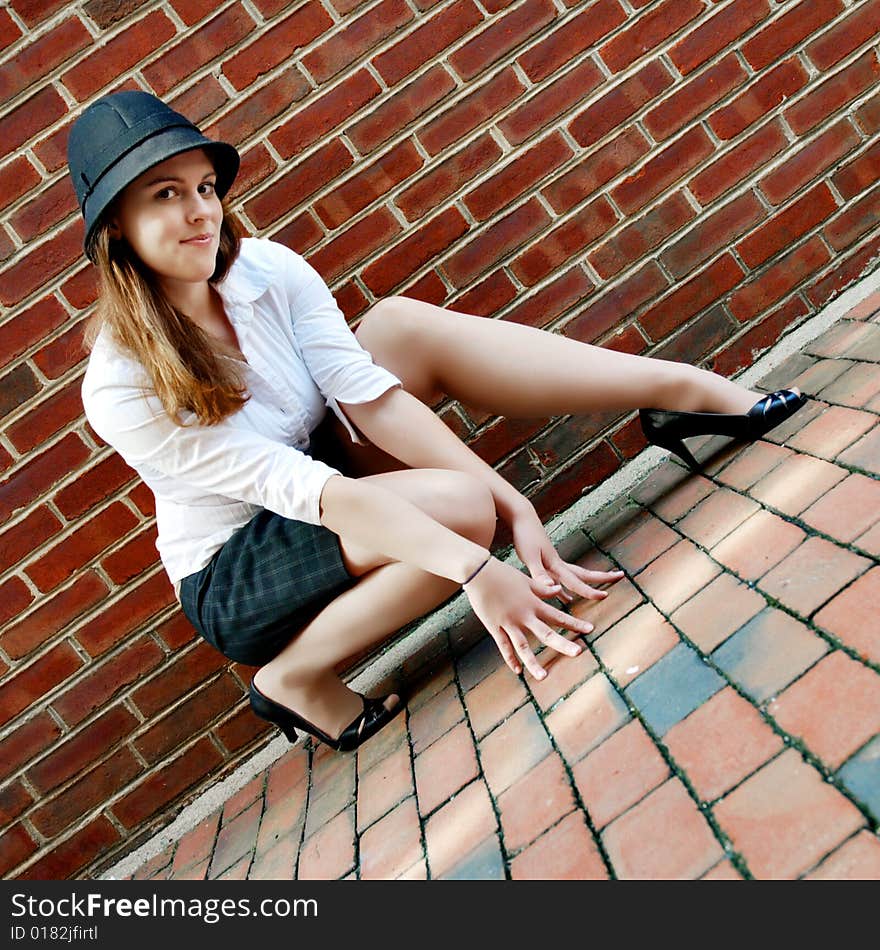 Fashionable young woman posing in front of a brick wall. Fashionable young woman posing in front of a brick wall.