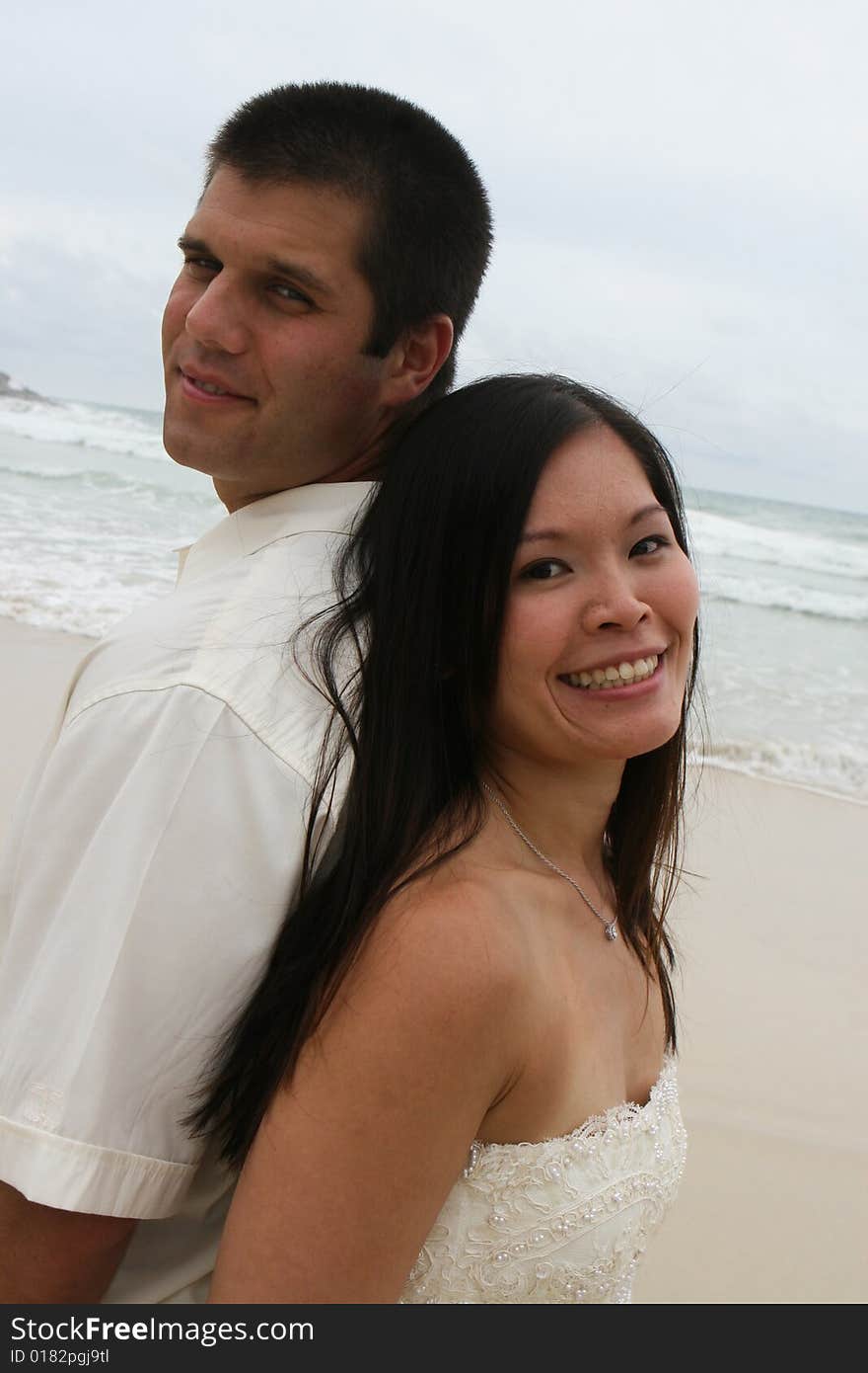 Portrait of an attractive bride and groom on the beach. Portrait of an attractive bride and groom on the beach.