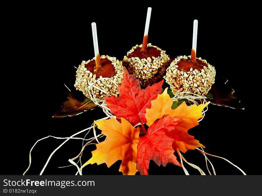 Caramel apples and fall leaves on a leaf plate. Caramel apples and fall leaves on a leaf plate.