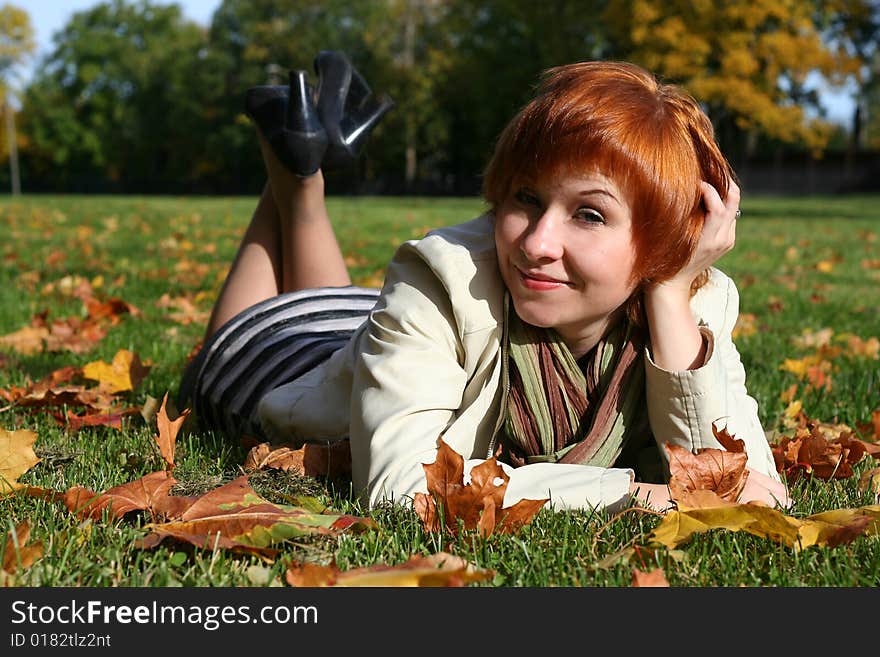 Red haired young woman in autumn park