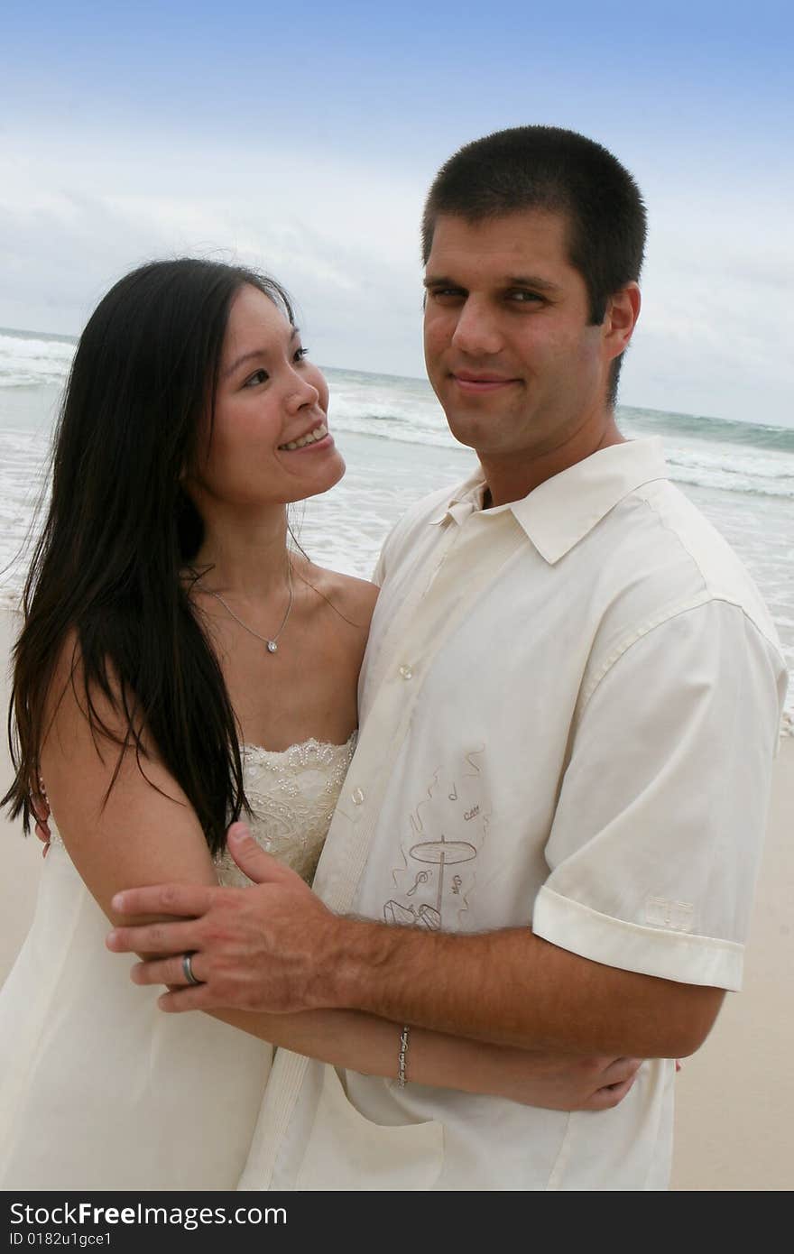 Portrait of an attractive bride and groom on the beach. Portrait of an attractive bride and groom on the beach.