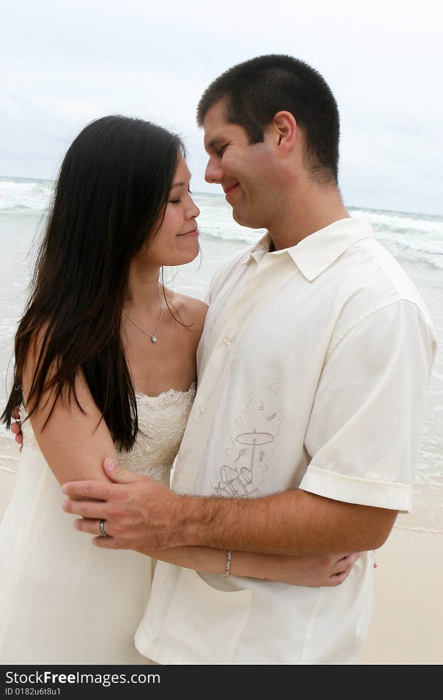 Portrait of an attractive bride and groom on the beach. Portrait of an attractive bride and groom on the beach.