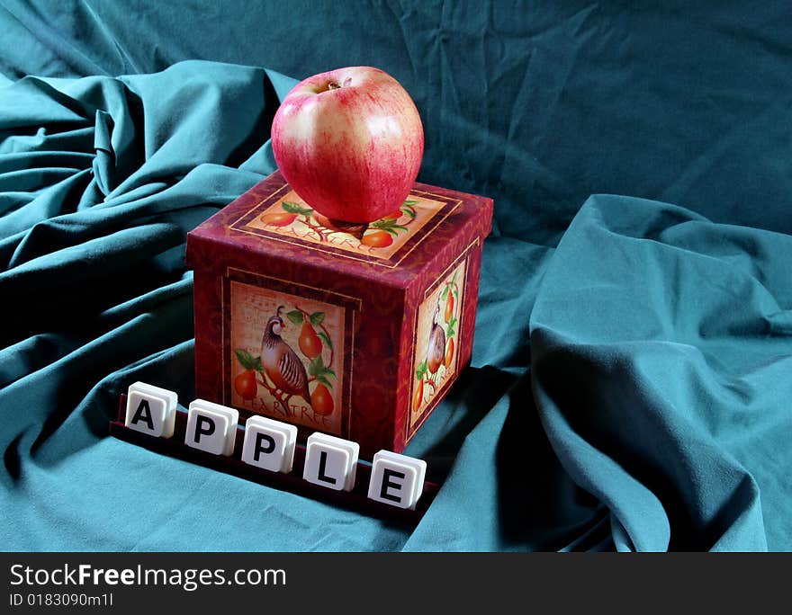 Apple on a box with the word apple in the foreground. Apple on a box with the word apple in the foreground