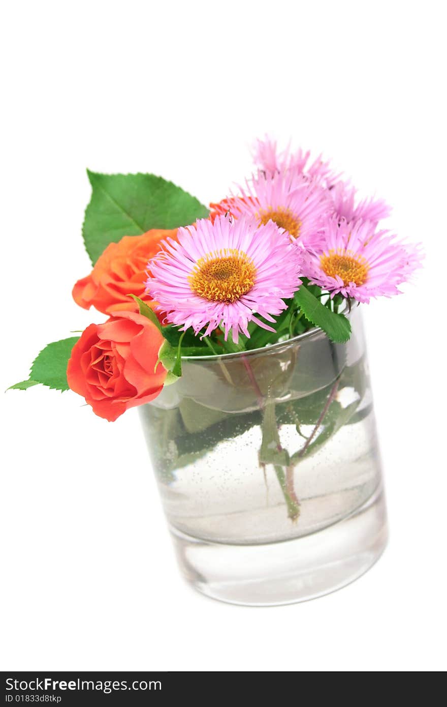 Small roses and daisies in a glass.Isolated. Small roses and daisies in a glass.Isolated.