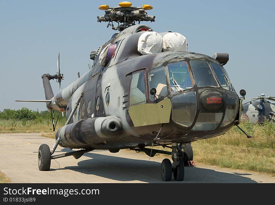 Helicopter parked on tarmac - not in the best condition. Helicopter parked on tarmac - not in the best condition