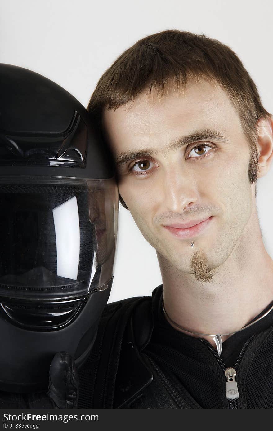 Portrait of smiling biker with had next to a sports helmet. Portrait of smiling biker with had next to a sports helmet