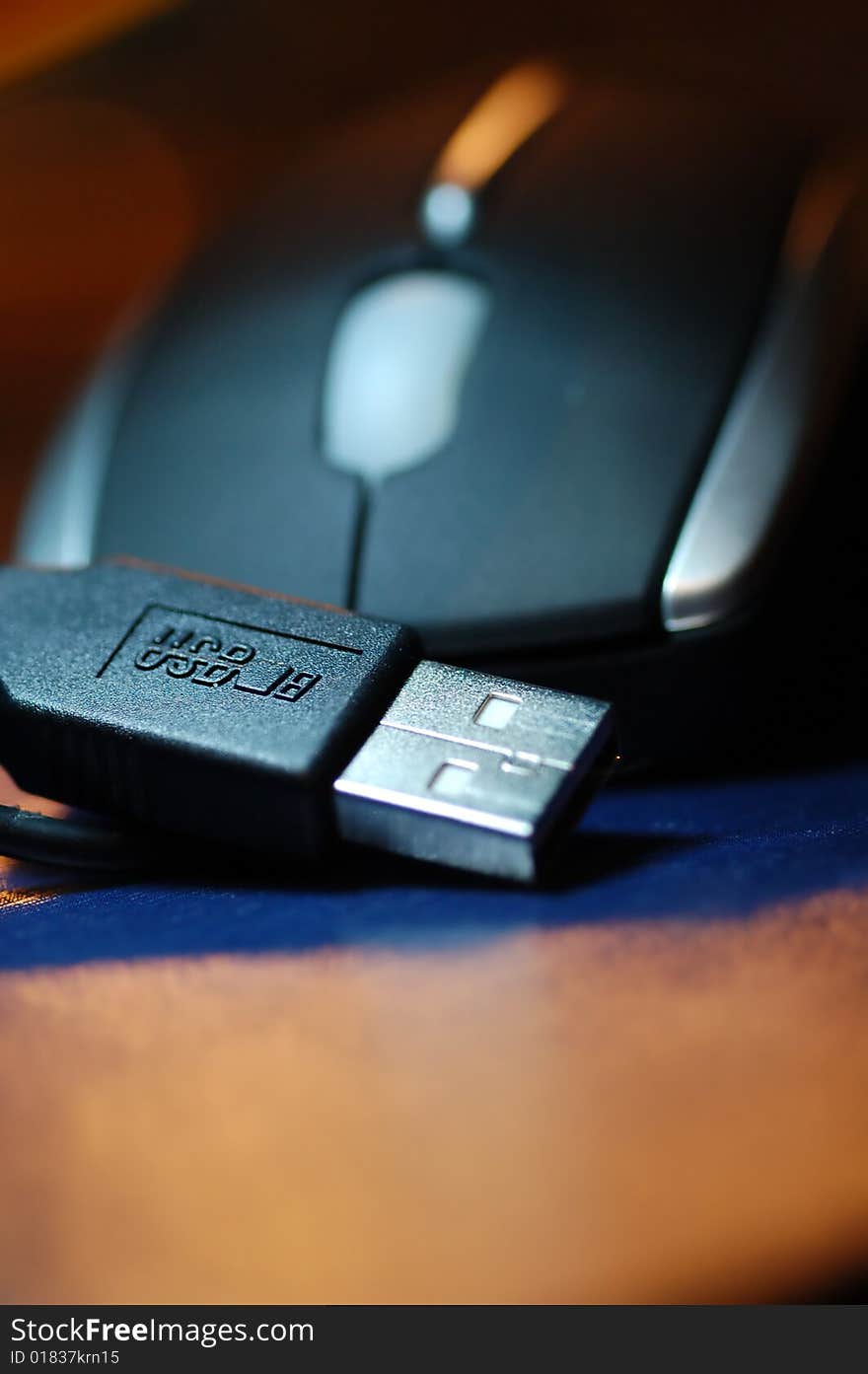 USB plug with mouse on a colourful background.